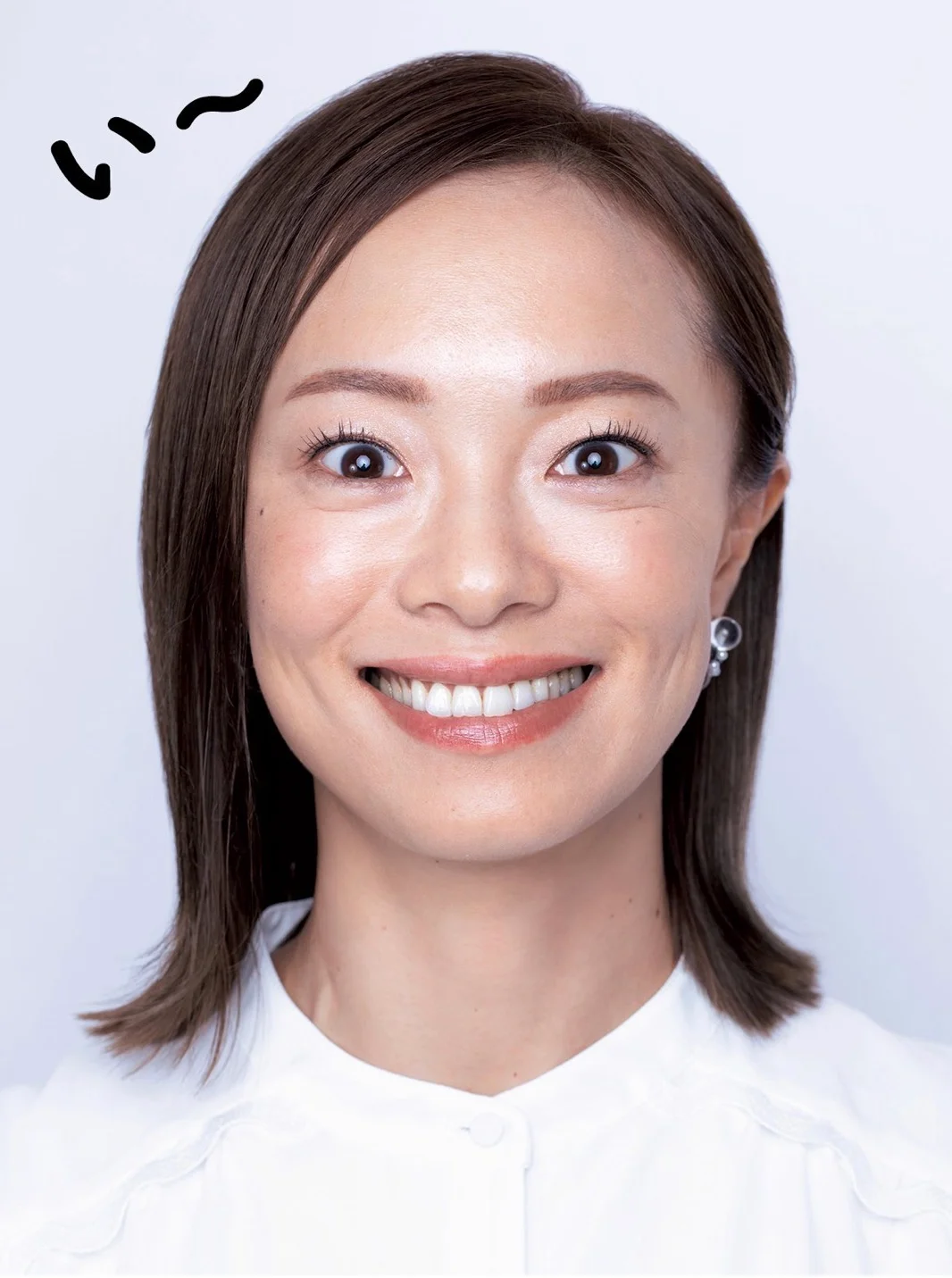 「い」のポーズの実演。口角を真横にグイッと引く