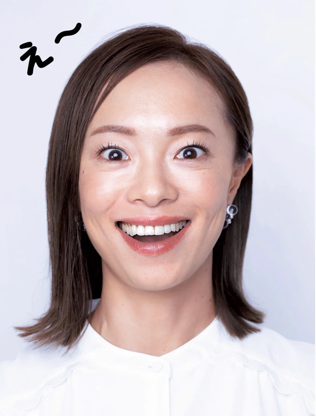 「え」のポーズの実演。人差し指を縦に挟み上の歯8本を見せる